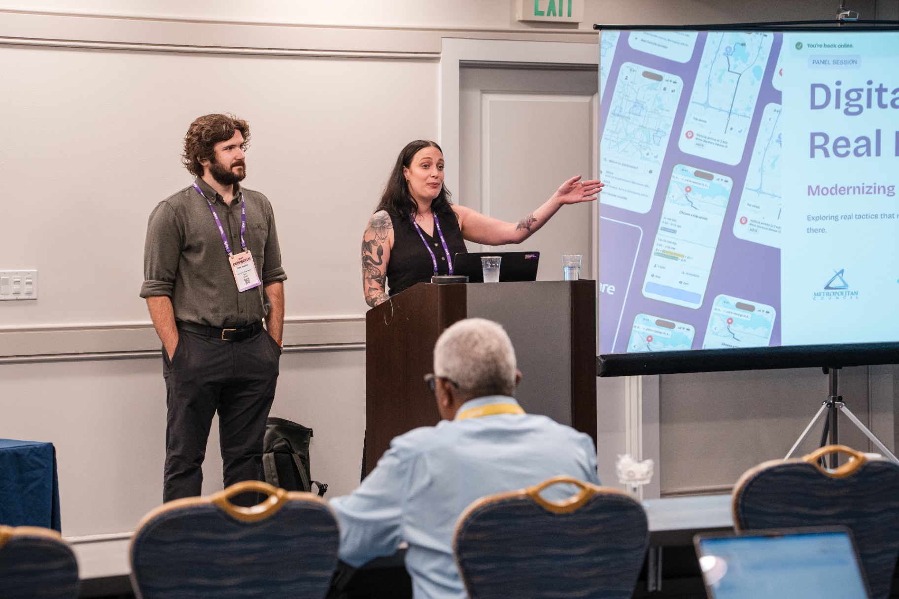 Breakout session presenters speaking beside the podium