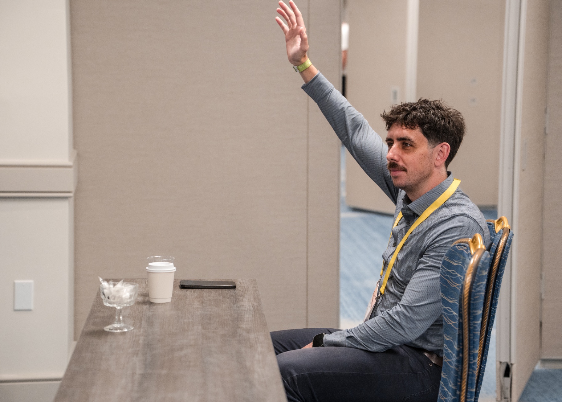 Attendee raising a hand to ask a question during a Day 1 session