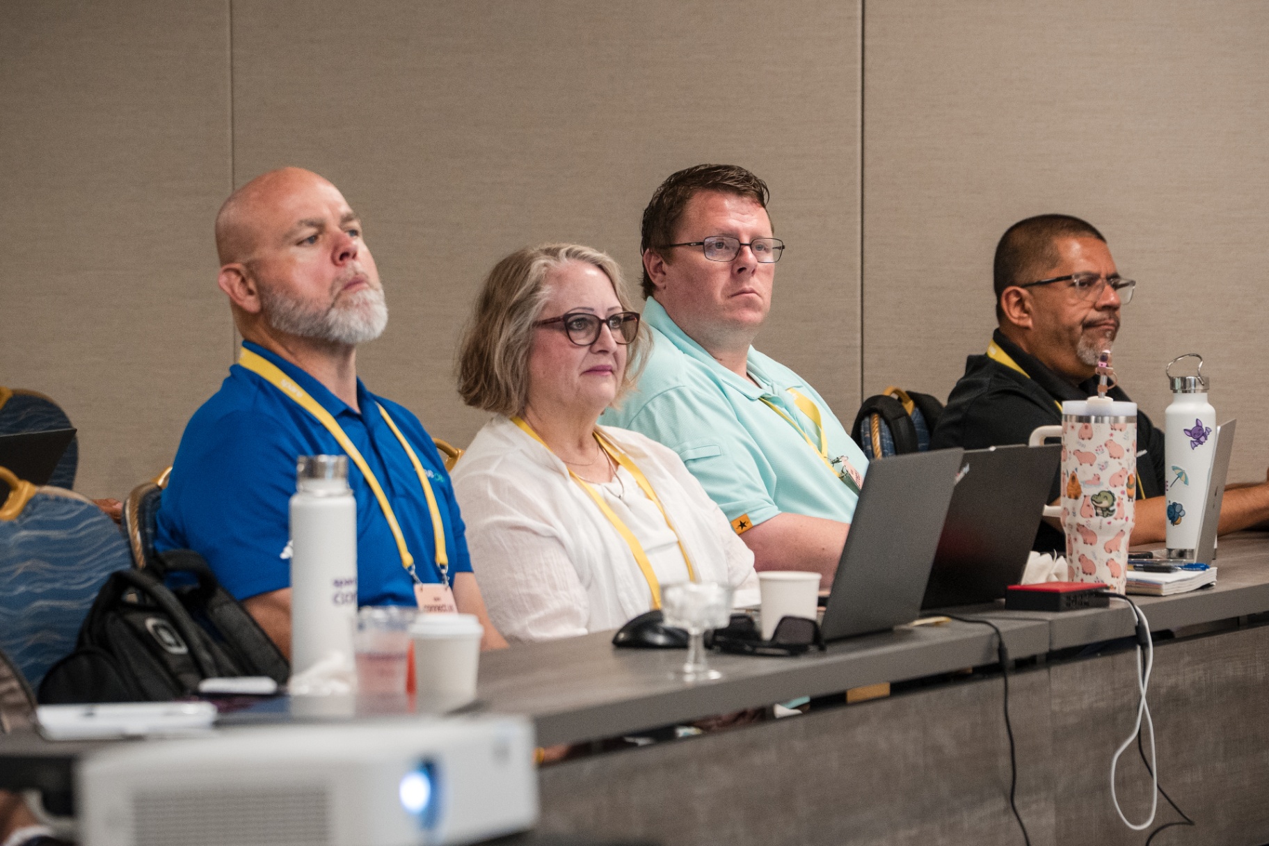 Close-up of four attendees listening intently in the front row