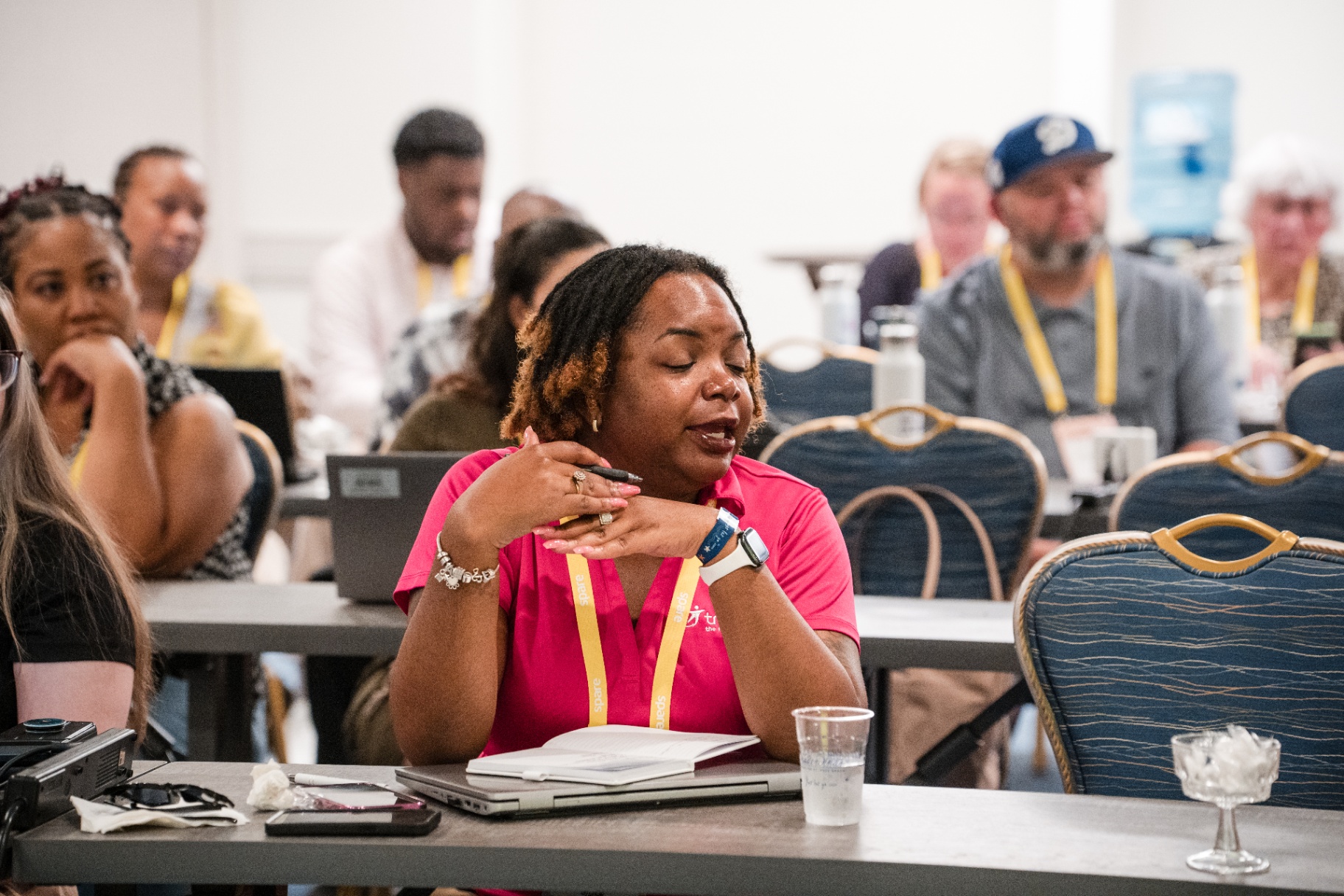 Attendee speaking during a Day 1 discussion with the room blurred behind