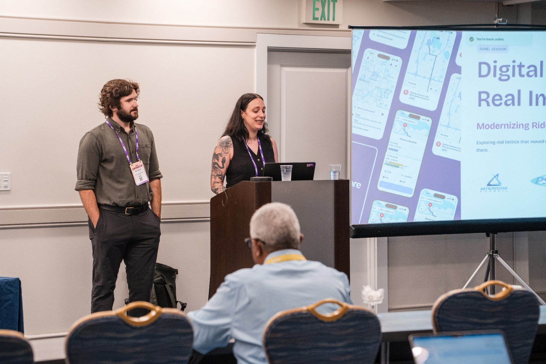 Two presenters leading a breakout session with a large screen deck