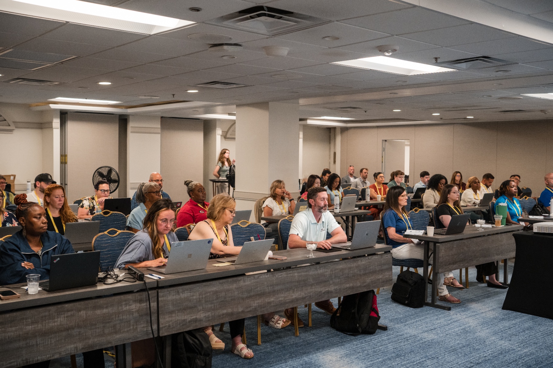 Packed breakout room of attendees with laptops during the Day 2 AI session