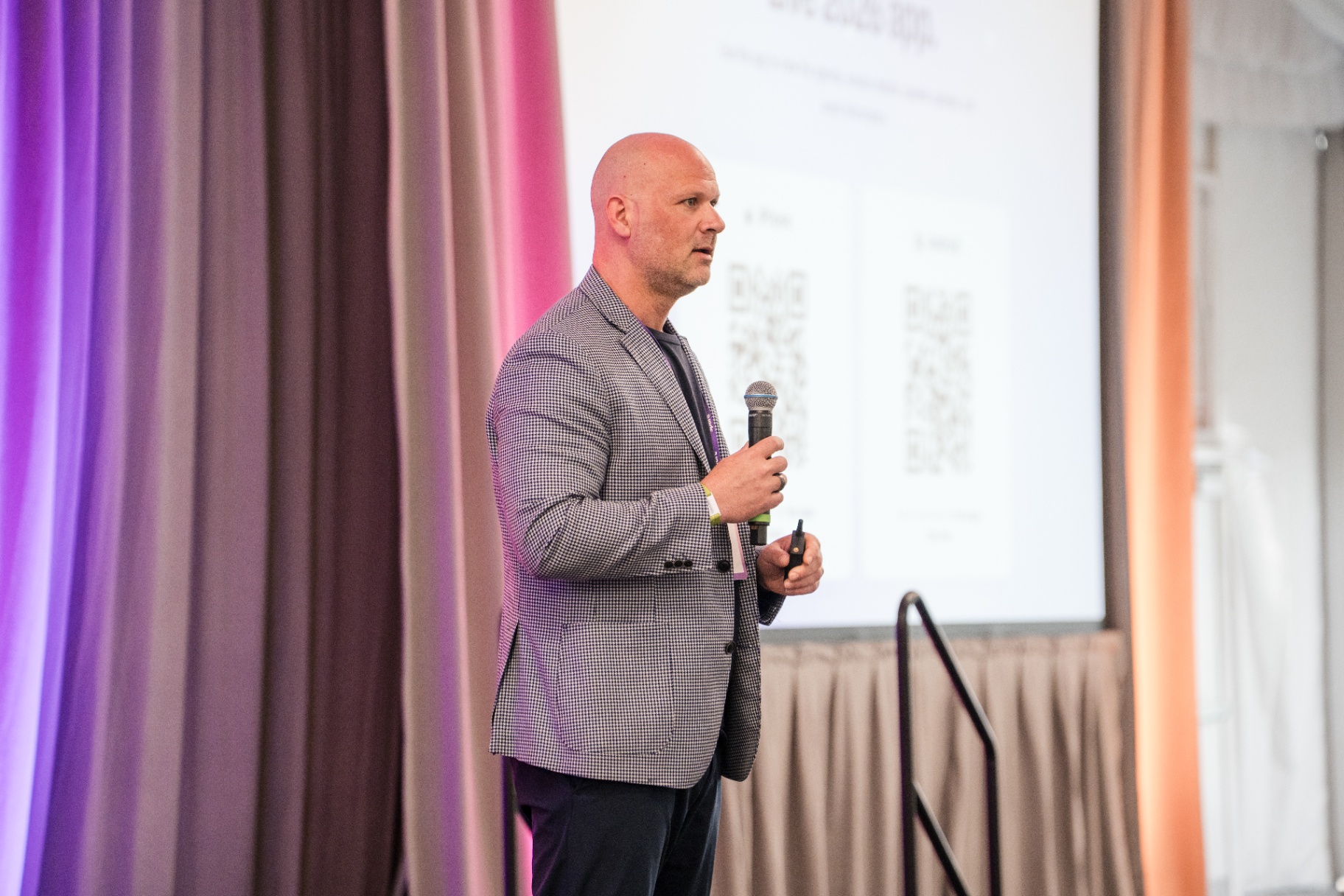 Executive speaker holding microphone during a Day 1 keynote