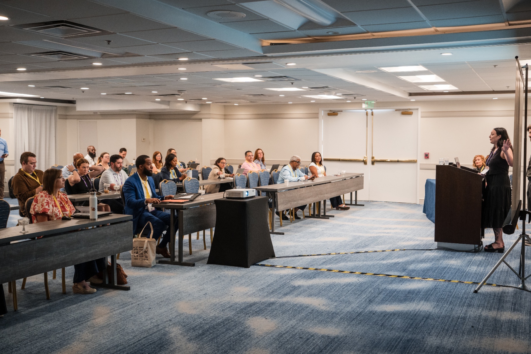 Audience listening to a speaker at the podium during Day 1