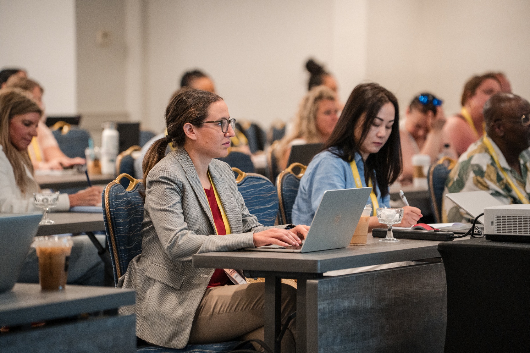 Focused attendees taking notes and working on laptops during the session