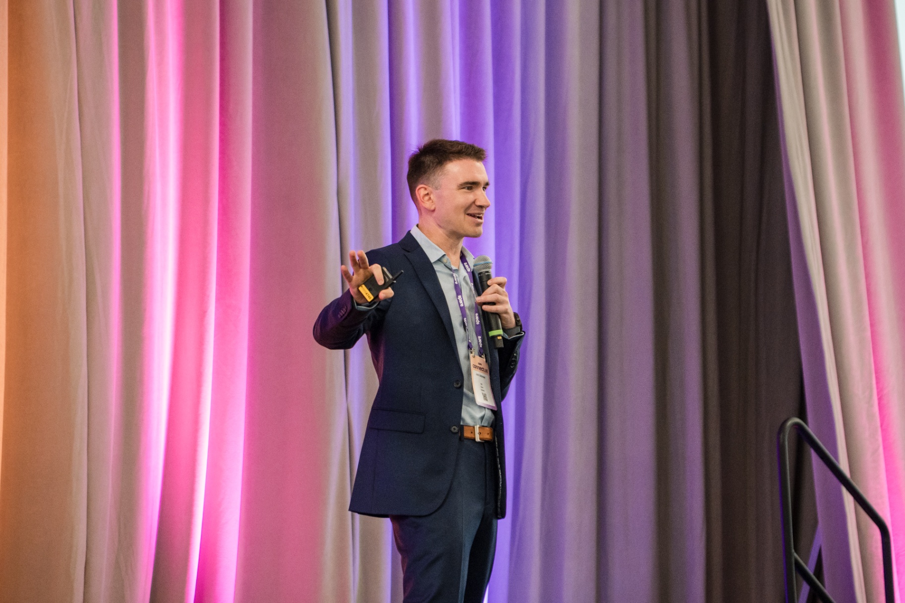 Keynote speaker gesturing on stage during Day 1